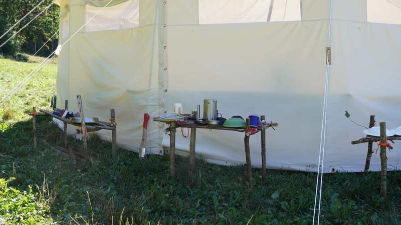 Die selbstgebauten Geschirrständer bei der Phönixzeit, im Hintergrund das Gruppenzelt